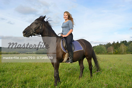 Teenage Girl Riding Arabo-Haflinger on Meadow, Upper Palatinate, Bavaria, Germany