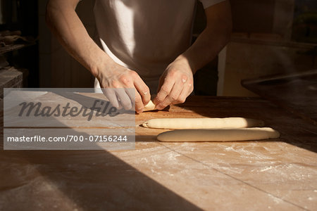 Close-up of male baker's hands kneading bread dough on floured board, Le Boulanger des Invalides, Paris, France Close-up of male baker's hands kneading bread dough on floured board, Le Boulanger des Invalides, Paris, France