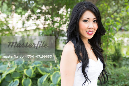 Close-up portrait of bride, standing in public garden, smiling and looking at camera, Ontario, Canada