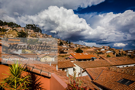 Overview of rooftops of homes with dramatic clouds, Cusco Peru