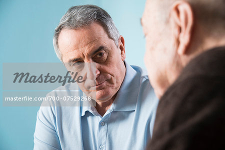 Close-up of senior, male doctor conferring with senior, male patient in office, Germany Close-up of senior, male doctor conferring with senior, male patient in office, Germany