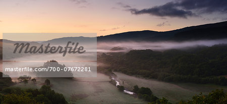 Misty wooded valley at dawn, summer, North Wales. Misty wooded valley at dawn, summer, North Wales.