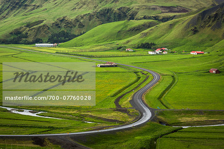 Scenic overview of farmland with winding road in spring, Vik, Iceland Scenic overview of farmland with winding road in spring, Vik, Iceland