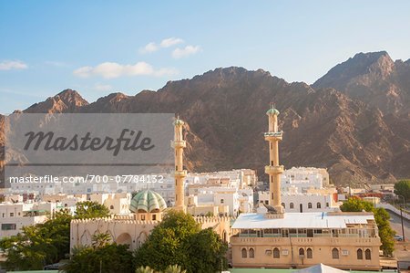 Cityscape with Two Towers of Mosque with Mountains in the background, Muscat, Oman