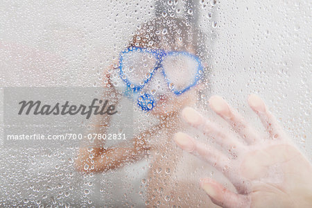 Boy Standing in Shower wearing Diving Mask and Snorkel