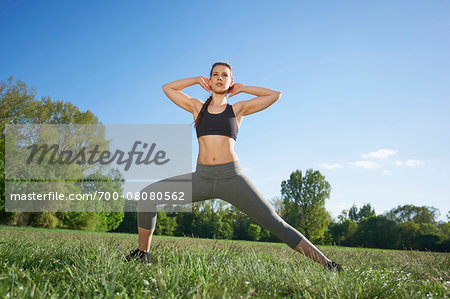 Close-up of a young woman exercising, stretching in a park in spring, Bavaria, Germany