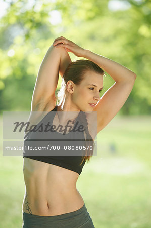 Close-up portrait of a young woman exrecising, stretching in a park in spring, Bavaria, Germany