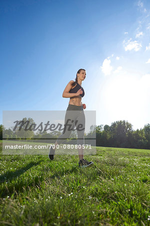 Young woman exercising, running in a park in spring, Bavaria, Germany