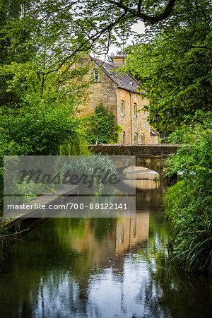 Small, arch bridge over River Windrush, Naunton, Gloucestershire, The Cotswolds, England, United Kingdom