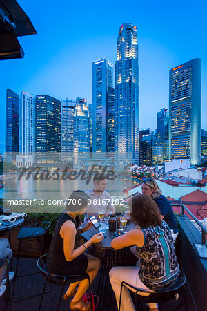 People at Bar at Boat Quay overlooking Skyline at Dusk, Singapore People at Bar at Boat Quay overlooking Skyline at Dusk, Singapore