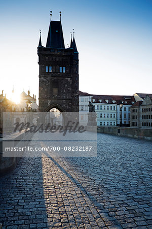 Charles Bridge with Old Town Bridge Tower and sun, Prague, Czech Republic.