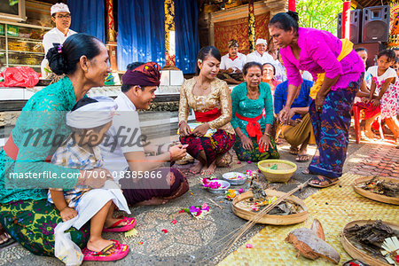 Family looking at religious offering at Balinese wedding, Petulu Village near Ubud, Bali, Indonesia Family looking at religious offering at Balinese wedding, Petulu Village near Ubud, Bali, Indonesia