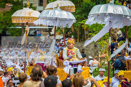 People being carried in raised chairs in pararde at a cremation ceremony for a high priest in Ubud, Bali, Indonesia