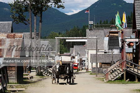 Man posing as a Prospector driving horse-drawn wagon through Barkerville Historic Town in British Columbia, Canada Man posing as a Prospector driving horse-drawn wagon through Barkerville Historic Town in British Columbia, Canada