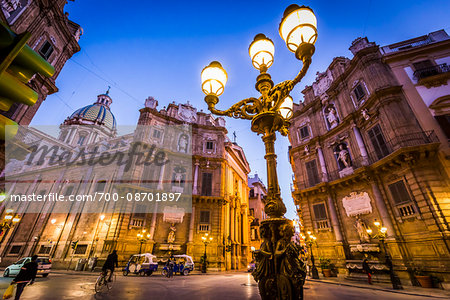 South and West buildings and illuminated lamp post at Piazza Vigliena (Quattro Canti) on Corso Vittorio Emanuele at dusk in Palermo in Sicily, Italy