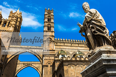 Statue of Archbishop and arcades connecting main building to the palace at the Palermo Cathedral in historic Palermo in Sicily, Italy