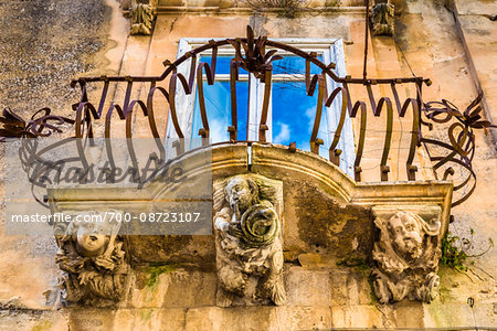 Baroque balcony railing with carved stone supports in Ragusa in Sicily, Italy