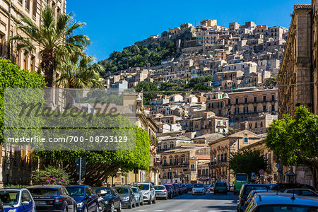 View of city street with homes on mountain side in historical Modica in the Province of Ragusa in Sicily, Italy