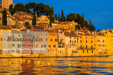 Waterfront with the sun reflecting on the buildings of the fishing port city of Rovinj on the north Adriatic Sea in Istria, Croatia