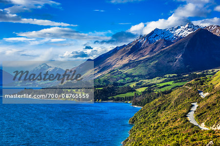 Scenic overview of mountains and Lake Wakatipu with shoreline road to Glenorchy in the Otago Region of New Zealand