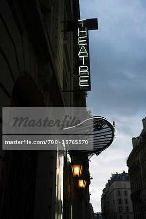 Front entrance to a typical Parisian theater with its neon sign and canopy, before the rain, France