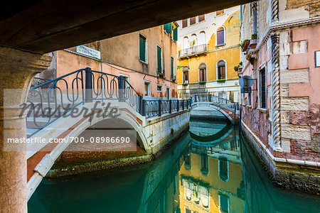 Looking through stone footbridges crossing a canal in Venice, Italy Looking through stone footbridges crossing a canal in Venice, Italy