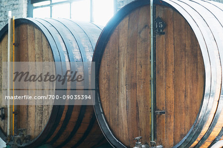 Close-up of whisky casks in front of a window in a traditional French distillery in northern France Close-up of whisky casks in front of a window in a traditional French distillery in northern France