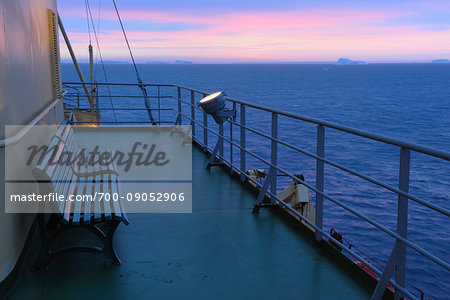 Bench on upper deck of icebreaker cruise ship, Kapitan Khlebnikov, with icebergs in the distance at sunrise at Snow Hill Island in the Weddel Sea, Antarctic Peninsula, Antarctica