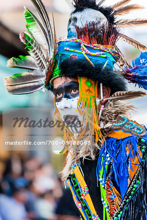 Close-up portrait of a young male, indigenous tribal dancer in colorful costume at the St Michael Archangel Festival parade in San Miguel de Allende, Mexico