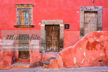 Pink, stone traditional buildings with wooden doors in San Miguel de Allende, Mexico