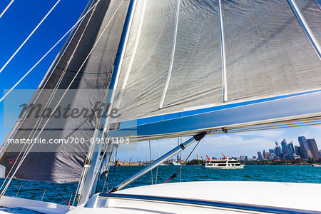 Close-up of sails on sailboat with yacht in the background, sailing in the Sydney Harbour in Sydney, New South Wales, Australia