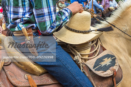 Close-up of cowboy in saddle on horseback in parade, riding to the Parroquia de San Miguel Arcangel in St Michael Archangel Festival, San Miguel de Allende, Mexico