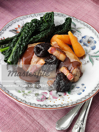 A plate of double pork chops with lardons prunes and cavolo nero