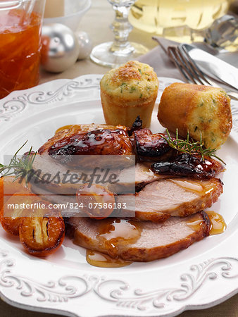 Individual portion of leg of pork slices with kumquat marmalade glaze and cheese chive muffins main meals