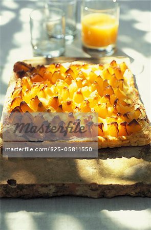 Apricot tart with glass of orange juice