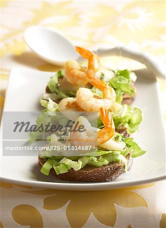 Scallops and shrimps on lettuce open sandwiches