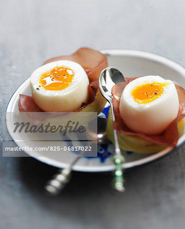 Soft-boiled eggs on artichoke bases with grisons meat