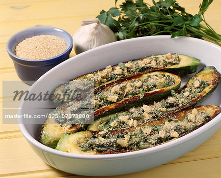 Filling the zucchini skins with the stuffing and sprinkle with breadcrumbs,parmesan and garlic