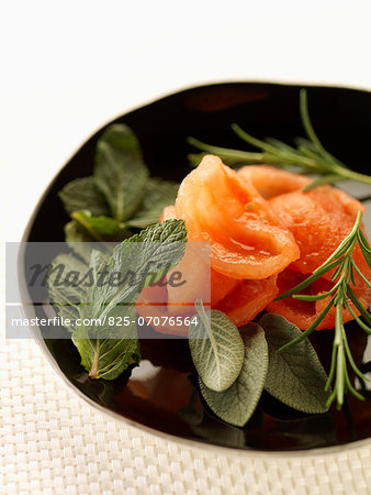 Plate of peeled tomatoes,mint,sage and rosemary