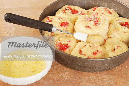 Brushing egg yolk onto the uncooked brioche dough