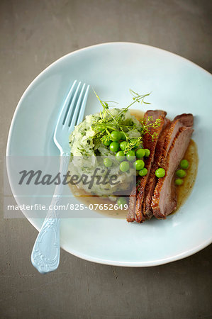 Sliced and roasted duck breast with turnips and peas