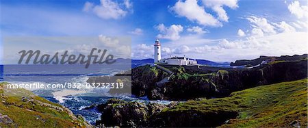 Waves breaking on the coast with a light house in background, Fanad Head, County Donegal, Republic Of Ireland