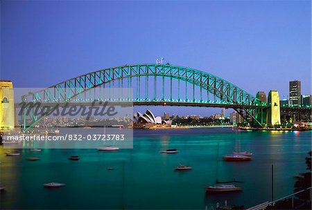 Sydney Harbour Bridge at dusk with Opera House behind