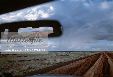 Dirt road reflected in rear view mirror