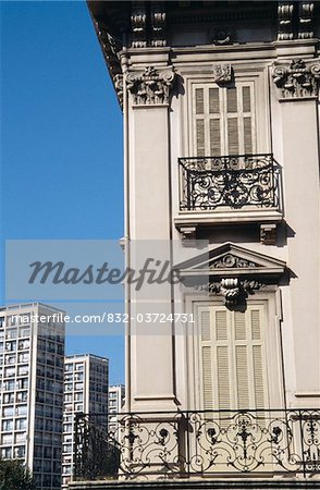 Traditional shuttered window and modern tower blocks