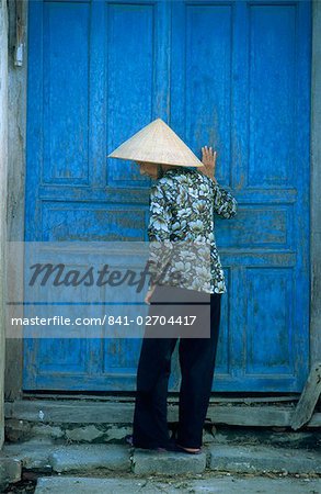 Elderly women wearing traditional hat, against door, Hou An, Vietnam, Indochina, Southeast Asia, Asia