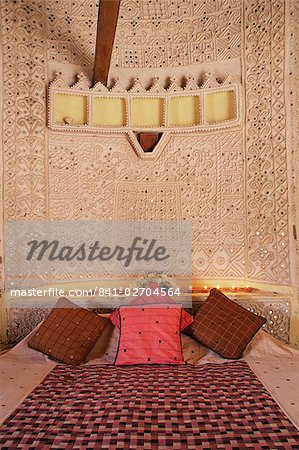Raised mud reliefs inlaid with mirror on the walls of bedroom in modern home in traditional tribal Rabari round mud hut, Bunga style, near Ahmedabad, Gujarat state, India, Asia