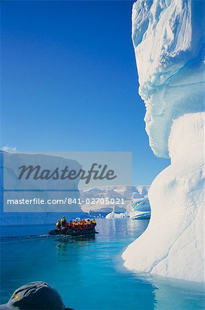 Tourists in inflatable cruising past icebergs, Antarctica