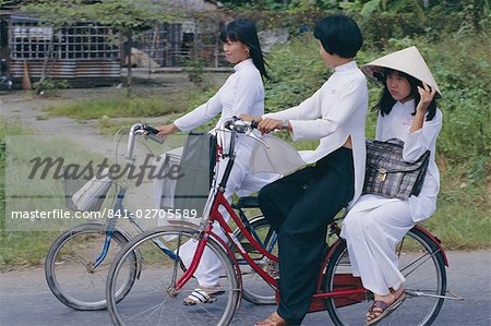 Girls riding bicycles, Ho Chi Minh City (Saigon), Vietnam, Indochina, Asia