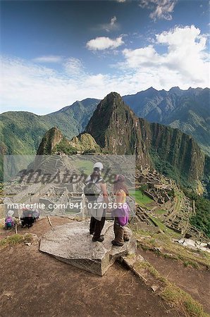 Tourists looking out over the ruins of the Inca site, Machu Picchu, UNESCO World Heritage Site, Urubamba Province, Peru, South America Tourists looking out over the ruins of the Inca site, Machu Picchu, UNESCO World Heritage Site, Urubamba Province, Peru, South America